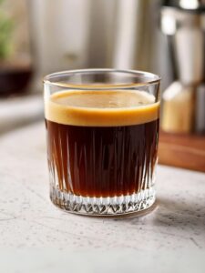 Cocktail Negrita Spresso servi dans un petit verre à café, avec une mousse onctueuse et une teinte sombre