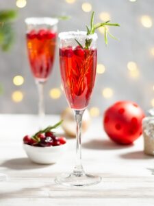 Cocktail de couleur rouge, au Champagne, triple sec et jus de cranberry. Il est présenté dans une coupe à champagne givrée avec du sucre. Le cocktail est décoré de canneberges et d'un brin de romarin.